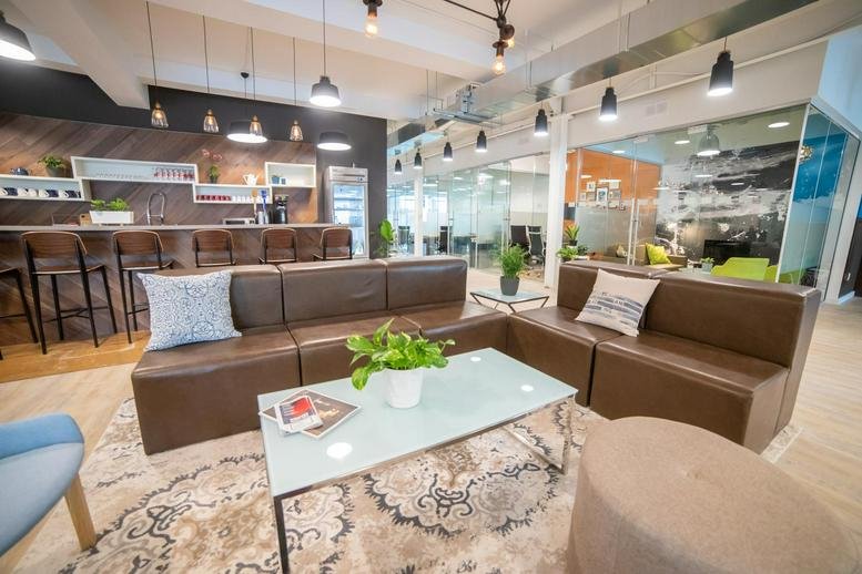 Spacious communal lounge at 146 Thirtieth Street, Suite 100 with leather sofas and a modern kitchen.