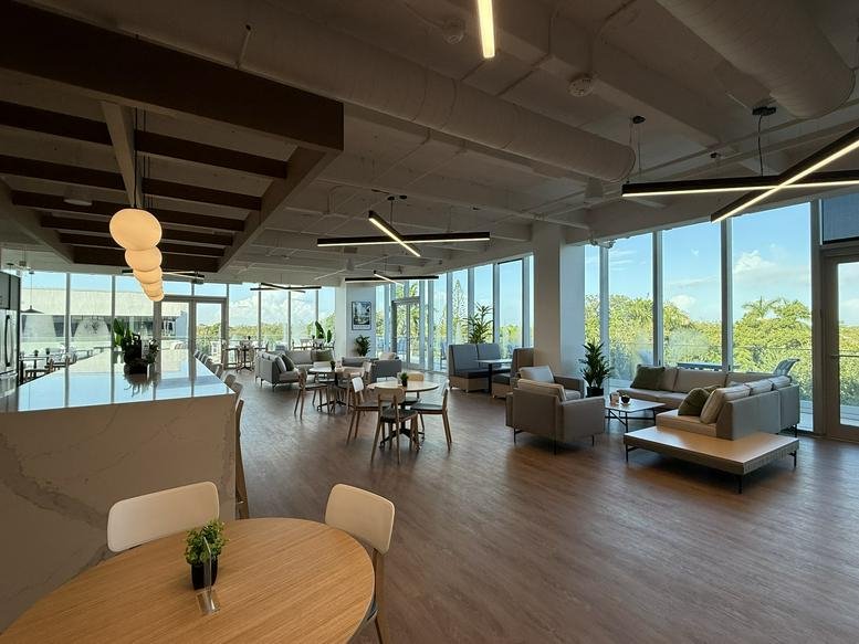 Spacious communal lounge at 1489, West Palmetto Park Road, Boca Raton with floor-to-ceiling windows and ample seating.