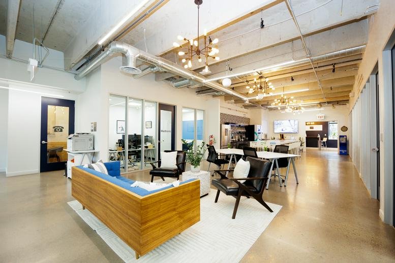 Spacious coworking lounge at 1495 Canyon Boulevard Downtown Boulder with modern wood furniture and industrial ceilings.