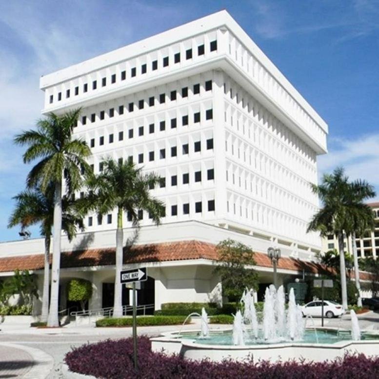 Exterior view of the white multi-story building at 150 East Palmetto Park Road.