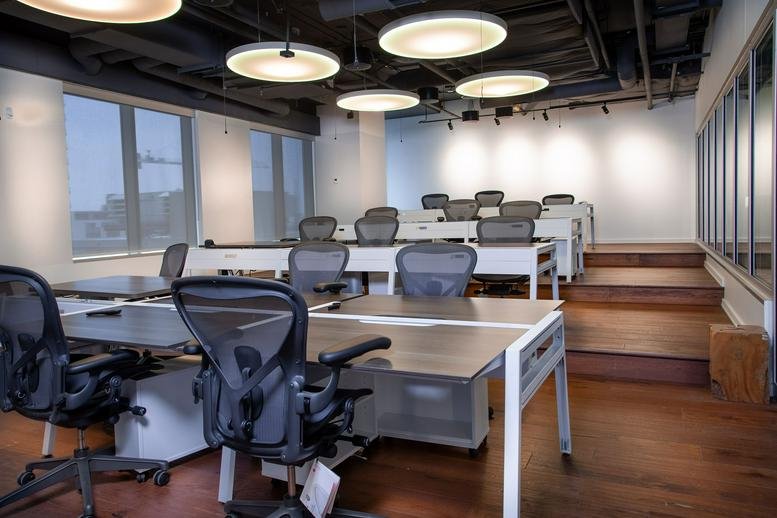 Open-plan office space at 150 Elgin Street, 10th Floor with ergonomic chairs and tiered wooden flooring.