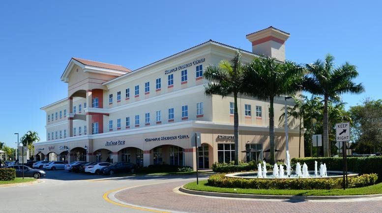 Exterior view of the multi-story Mediterranean-style building at 15800 Pines Boulevard.