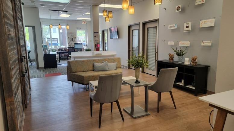 Warm communal lounge at 1617 Park Place Avenue, Suite 110, with soft seating and hanging pendant lights.