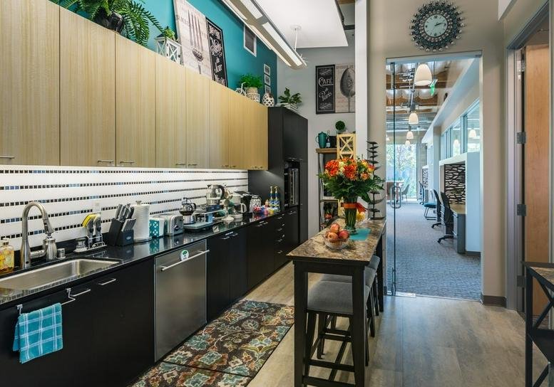 Bacchus Office Park kitchen area with modern black cabinetry, wooden cupboards, and a teal accent wall.