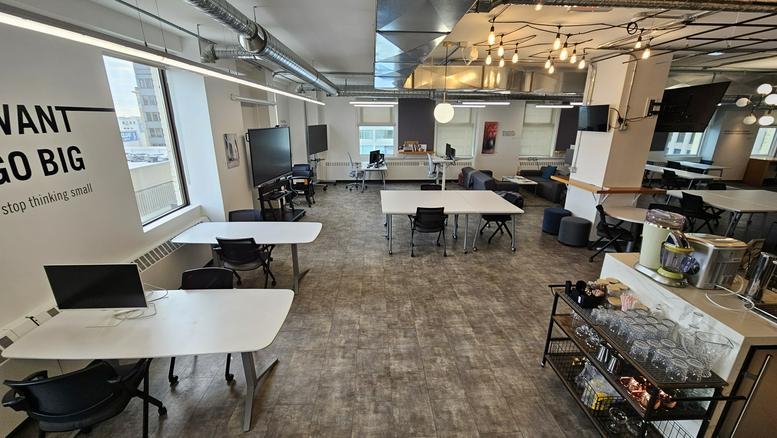 Large open common area at 167 Lombard Avenue with flexible workspaces and pendant lighting.