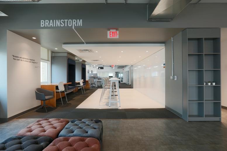 Wide-angle view of the brainstorm zone at 167 Lombard Avenue with whiteboards and colorful seating.