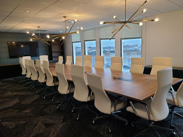 Spacious boardroom at 1701 Golf Rd, Tower 3, Floor 3, with wooden table and modern light fixtures.