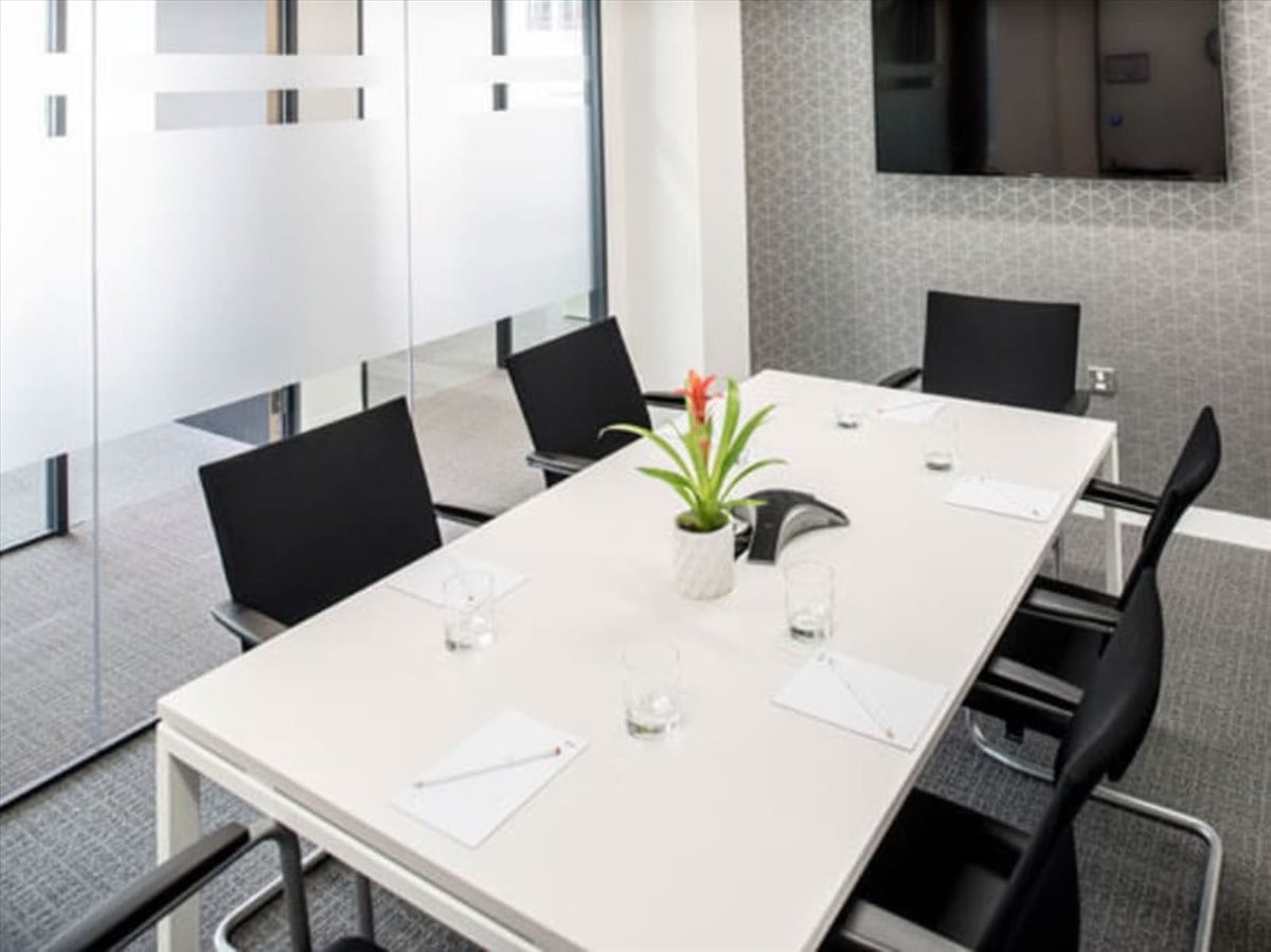 Bright conference room at 1750 Howe Avenue, The Landmark, with a white table and black chairs.