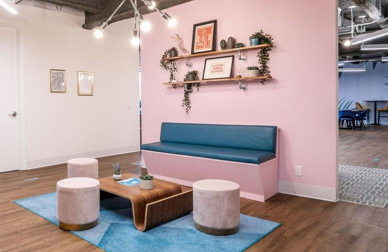 Spacious reception lounge at 180 Dundas St. W, 25th Floor with pink walls and a blue bench.