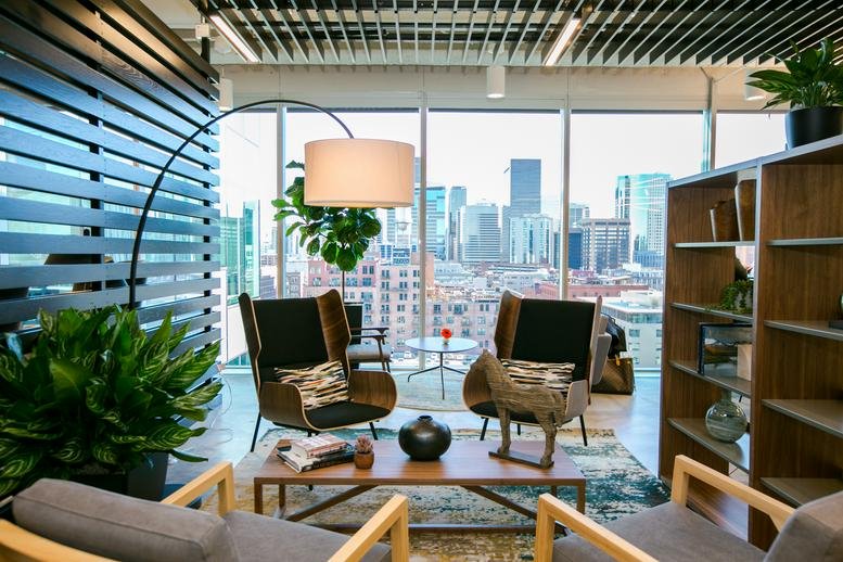 Lounge area at 1801 Wewatta Street, 11th Floor, with designer chairs and floor-to-ceiling city views.
