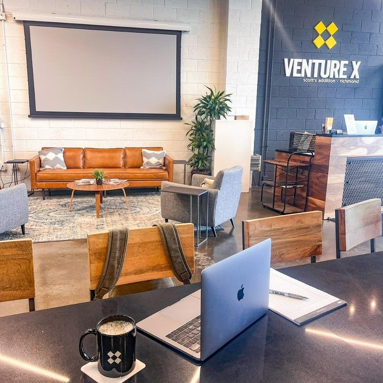 Spacious coworking lounge at 1806 Summit Avenue with leather sofas and projector screen.