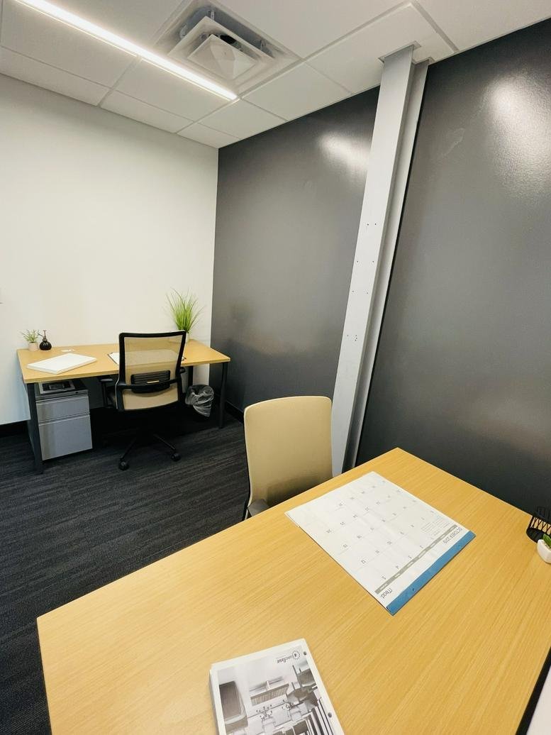 Bright workspace at 1806 Summit Avenue, Suite 300 with two desks and a glass partition.