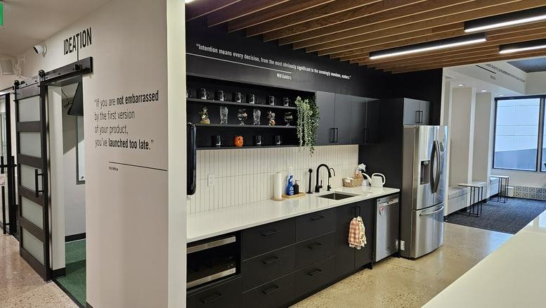 Modern kitchen with black cabinetry and a wood slat ceiling at 185, Carlton Street No. 200.
