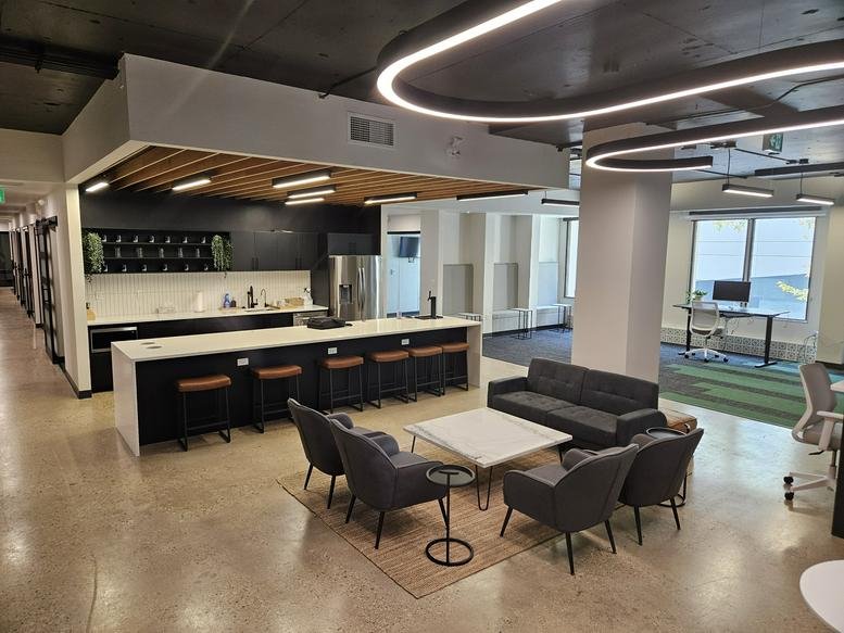 Wide-angle view of a common area with a long white island and lounge seating.