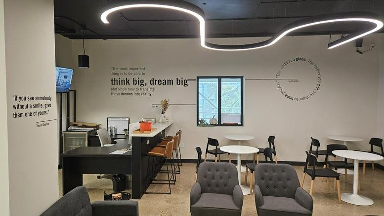 Bright breakout area at 185, Carlton Street No. 200 with stylish seating and an S-shaped light fixture.