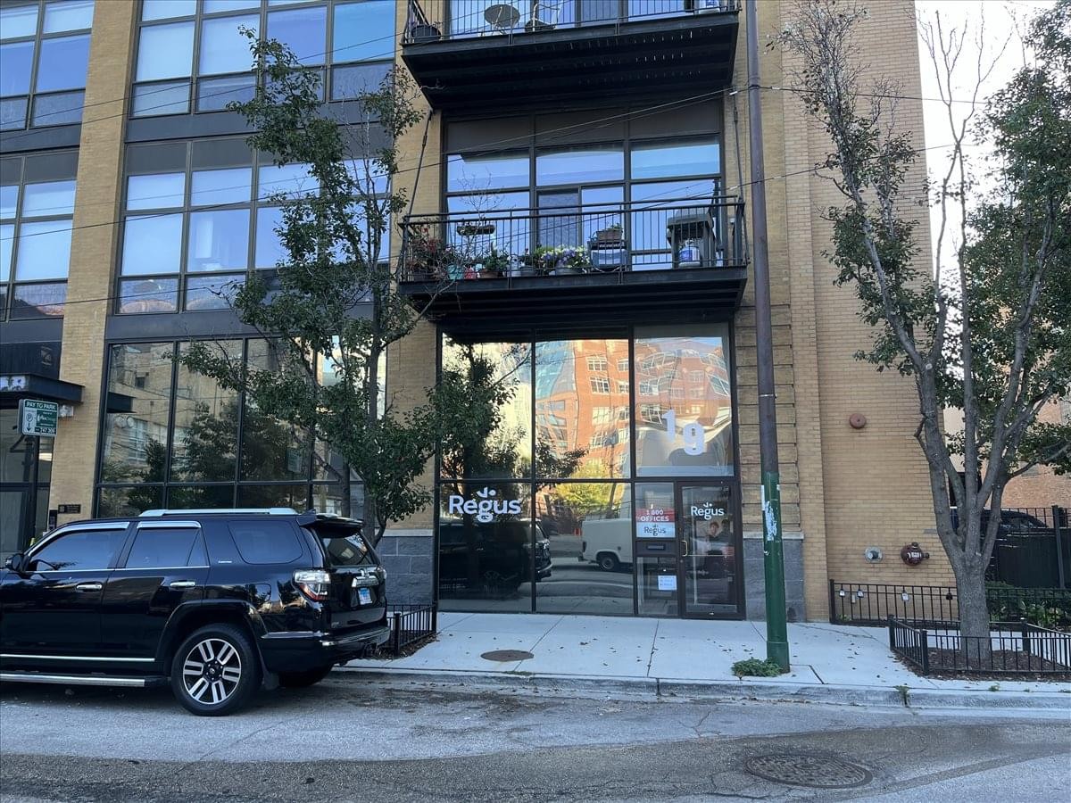 Exterior facade of 19 North Green Street with glass storefront and balconies.