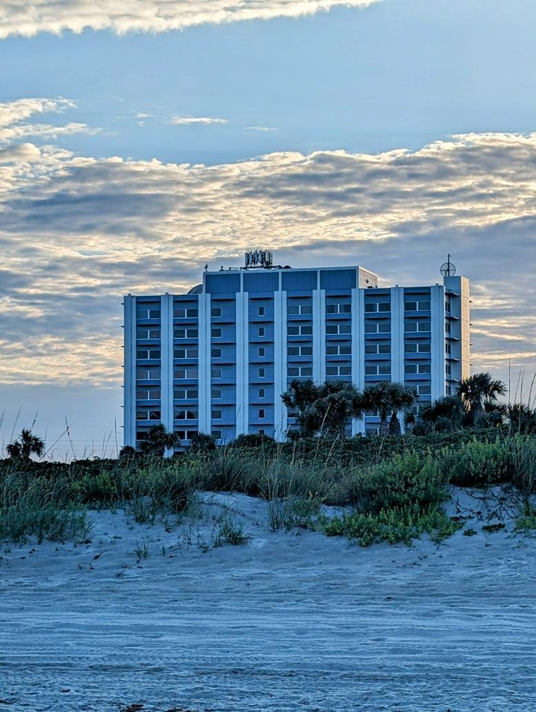 Exterior view of the multi-story blue and white building at 1980 N Atlantic Ave, Second Floor, Cocoa Beach.
