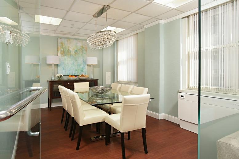 Sophisticated boardroom at 20 Park Plaza with a glass table and tiered chandelier.