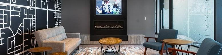 Spacious lounge area at 20 Pugsley Court with a modern fireplace, wall mural, and comfortable seating.