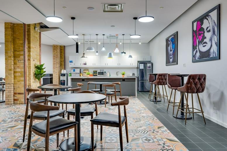 Spacious communal dining area at 20 Richmond St E, Suite No. 600 with patterned tile floors and colorful wall art.