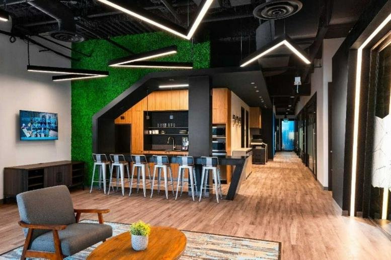 Modern lounge and break area at 200 Fairbank Avenue with a green feature wall and stylish lighting.