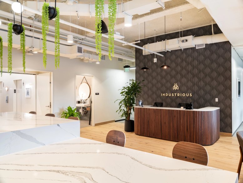 Reception area at 2001 Clayton Road featuring a wood-slat desk and branded dark textured wall.