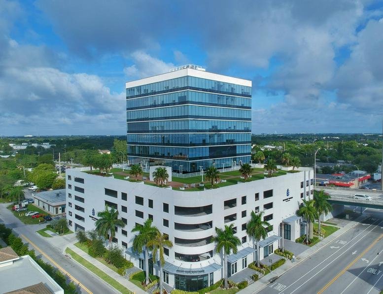 Aerial view of the modern glass office building at 20200 West Dixie Highway with rooftop greenery.