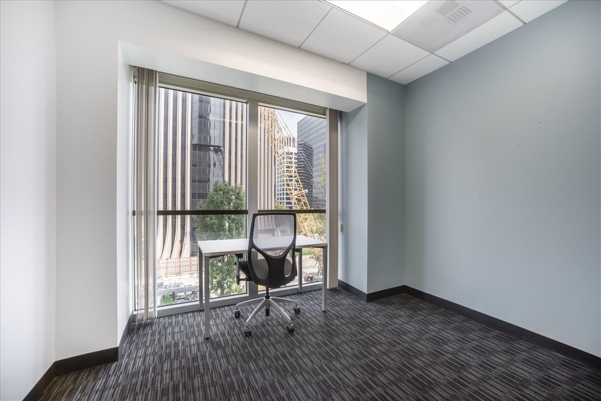 Private office at 2029 Century Park East with city skyscraper views and ergonomic task chair.