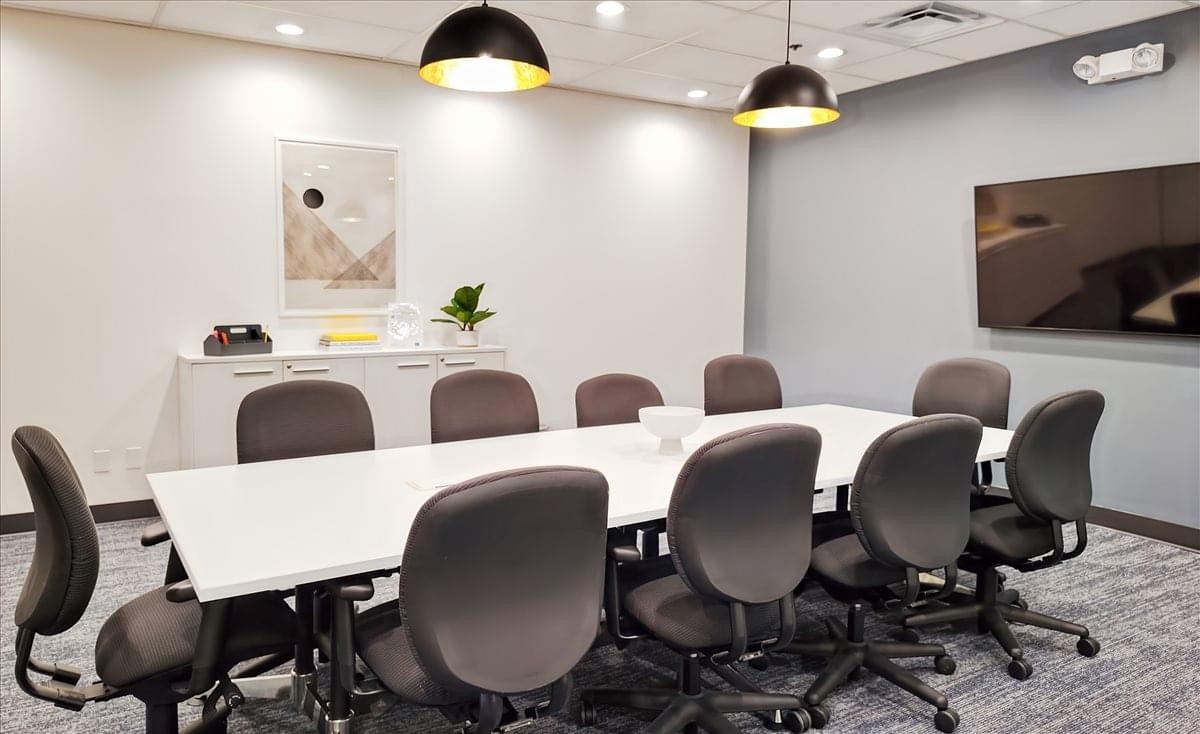 Professional meeting room at Church Street Square with a long white table and modern pendant lighting.