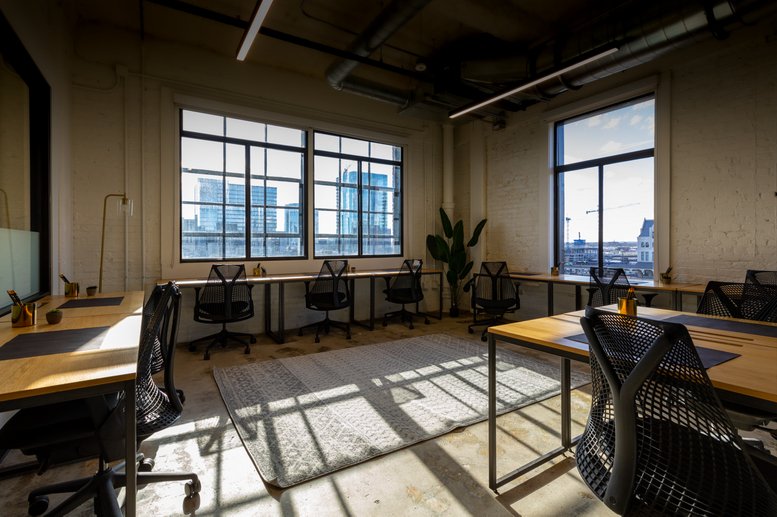 Open office at 209, 10th Avenue South, Suite 560 featuring high ceilings and sunlit workspaces.