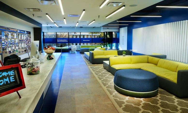 Bright reception lobby at 2098 Gaither Road with lime green seating and a long white service counter.