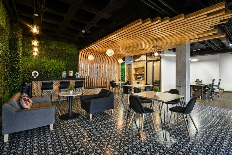Spacious communal lounge at 2101, Paseo de las Américas, Guadalupe with wooden slats and a green feature wall.
