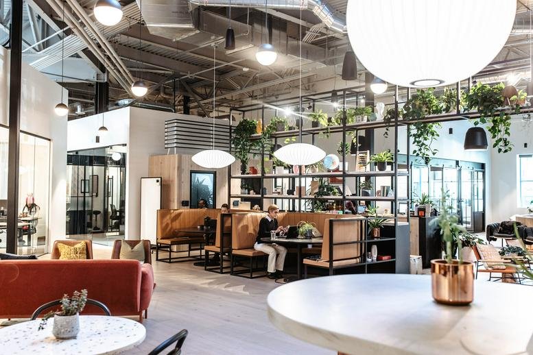 Spacious open-plan common area at 2162 East Williams Field Road with cafe seating and industrial ceilings.