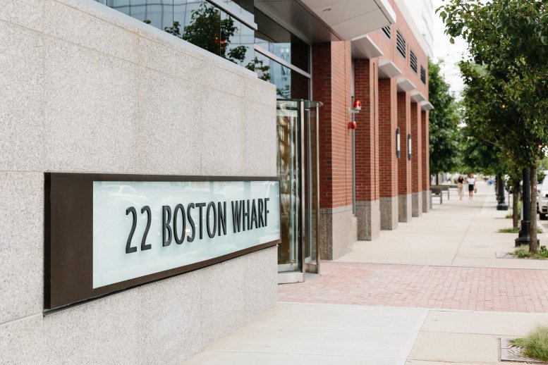 Exterior entrance signage on a stone wall at the 22 Boston Wharf Road building.