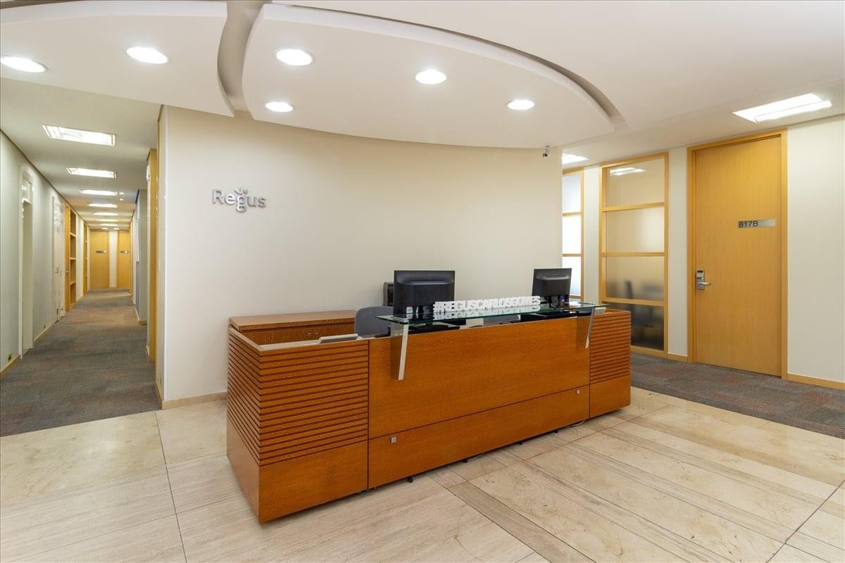 Professional reception area with a polished wood front desk and warm overhead lighting.