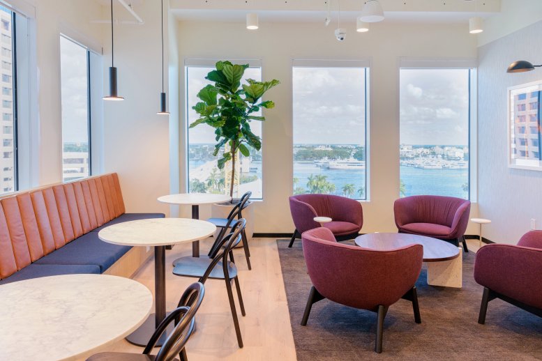 Spacious coworking lounge at 222 Lakeview Avenue with colorful seating, marble tables, and waterfront views.