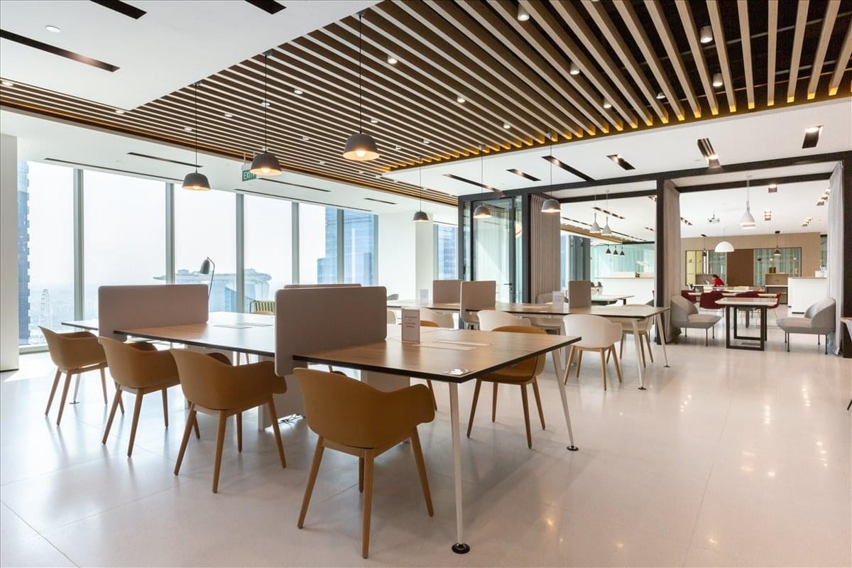 Large open-plan workspace featuring wooden slat ceilings and rows of modern workstations.