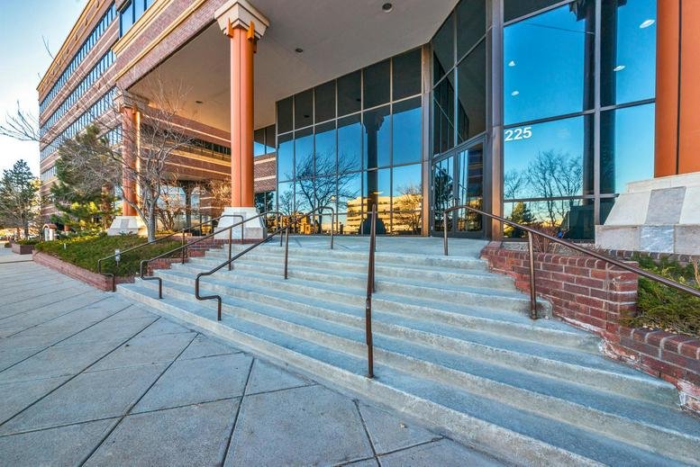 Exterior entrance of 225 Union Boulevard, Suite 150, Lakewood (Colorado) with glass facade and stone pillars.