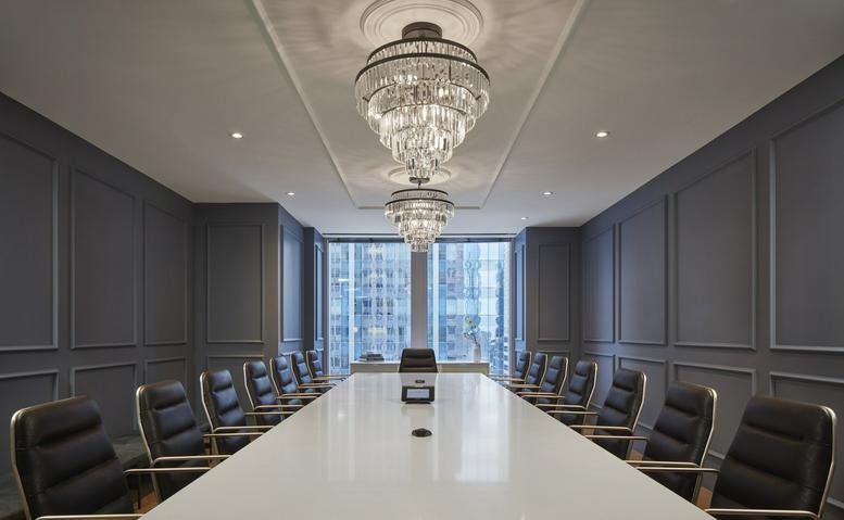 Elegant formal boardroom at The Franklin with a white marble table and crystal chandeliers.