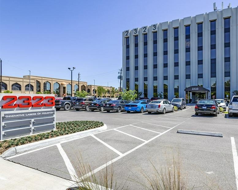 Exterior view of the multi-story office building at 2323 South Voss Road with adjacent parking lot.