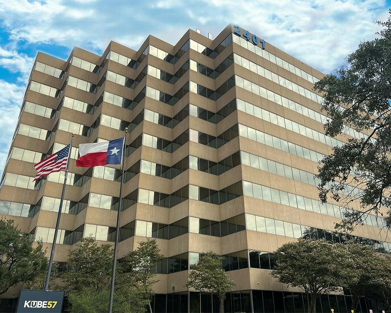 Low-angle exterior view of the tiered tan building at 2401 Fountain View Drive.