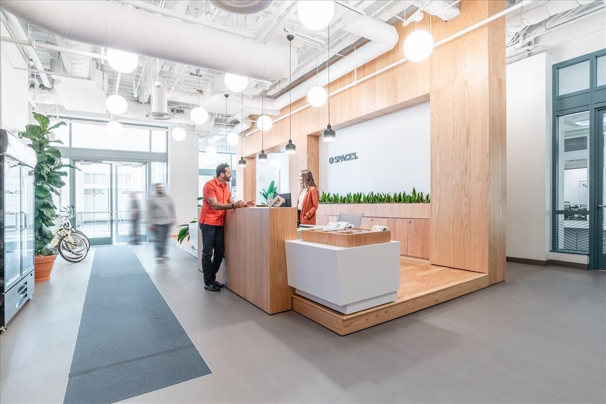 Bright reception desk at 2450 Colorado Avenue, Suite 100E, featuring light wood paneling and warm pendant lighting.