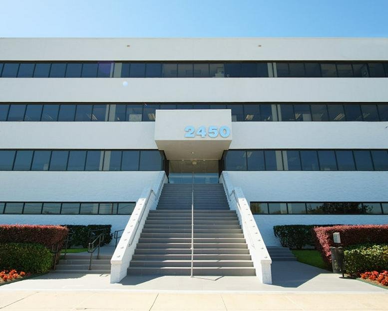 Front exterior of 2450 NASA Parkway showing the white facade and symmetrical staircase.