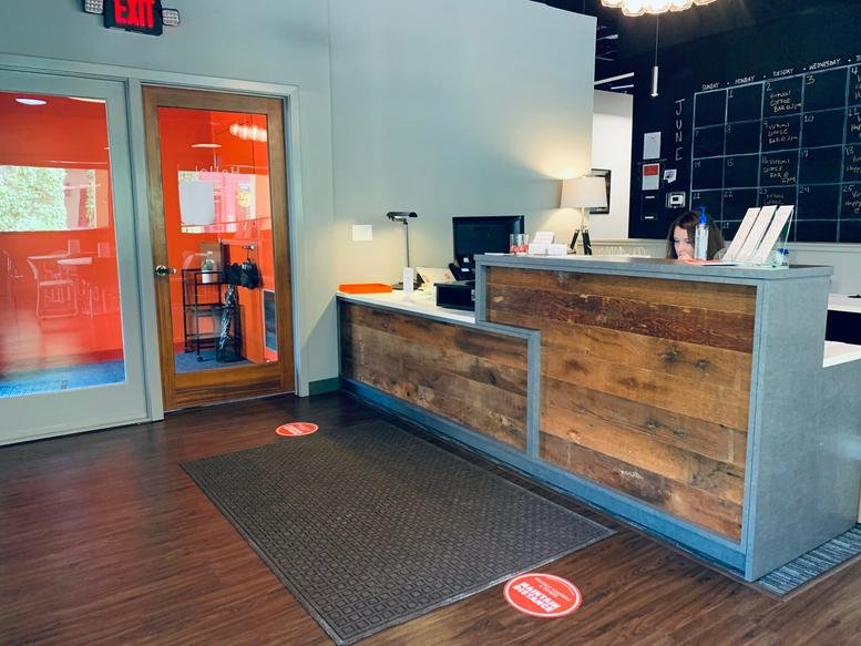 Reception area at 25 North River Lane, Geneva (Illinois) featuring a rustic wood-paneled desk and warm lighting.