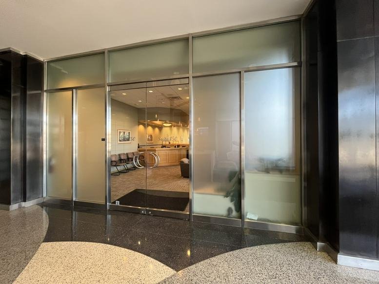 Glass entrance doors to the modern suite at 250 Parkway Drive, Suite 150.