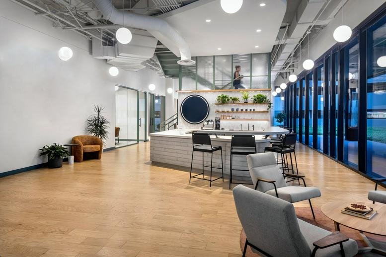 Spacious lounge and cafe at 2500 CityWest Boulevard, Suite 150, with wood floors and modern light fixtures.