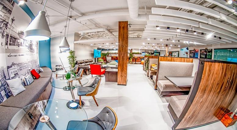 Spacious communal lounge at 252 Esplanade West, Suite 201 with varied seating and modern pendant lighting.