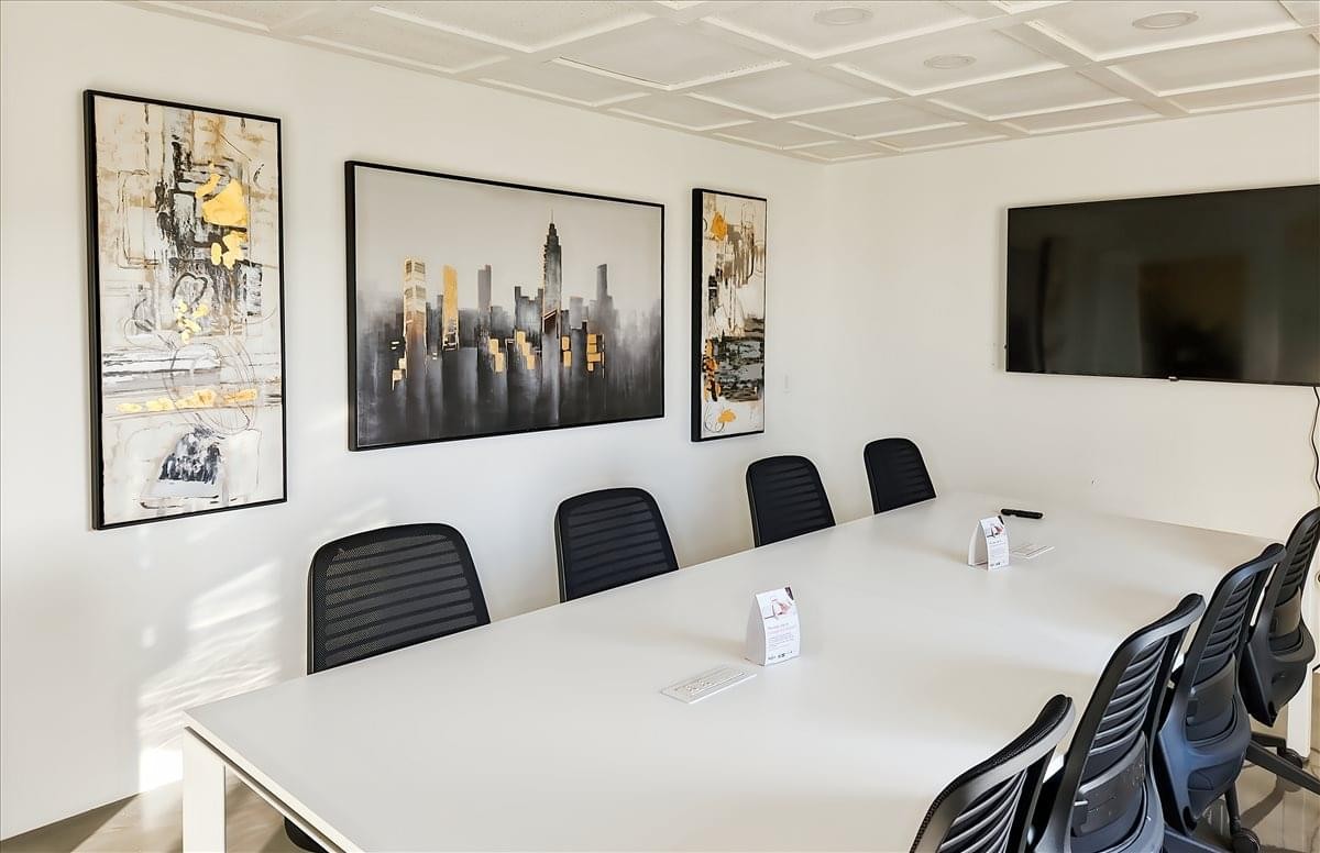 Meeting room at 2563 Development Drive, 1st & 2nd Floor featuring a large white table and city skyline wall art.