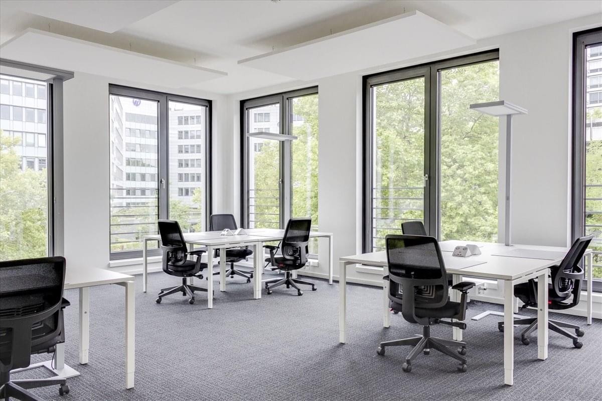 Spacious open-plan workspace at 27301 Dequindre Road with white desks and large windows.
