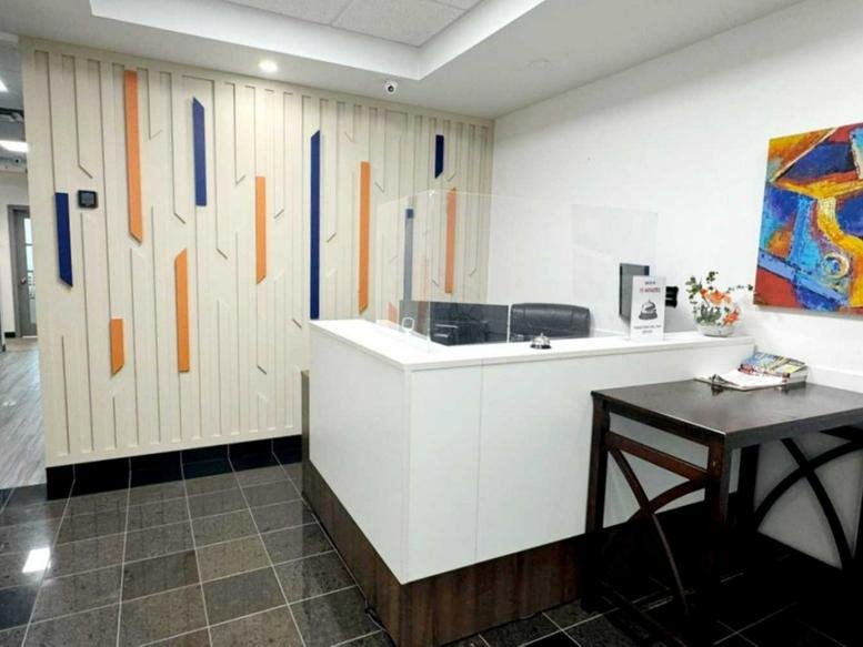 Modern reception desk at 2985 Drew Road, Mississauga featuring a colorful accent wall and geometric art.